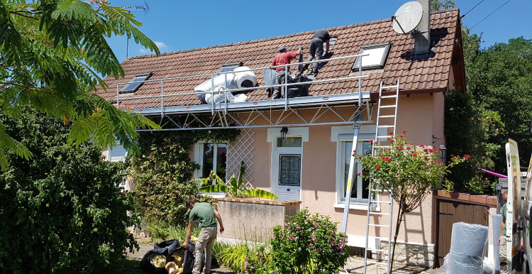Chantier d’isolation de toiture en plein été, couvreurs sur le toit et garde-corps