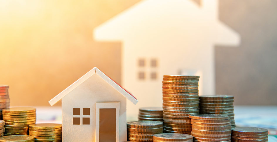 Maisons miniatures entourées de piles de pièces de monnaie