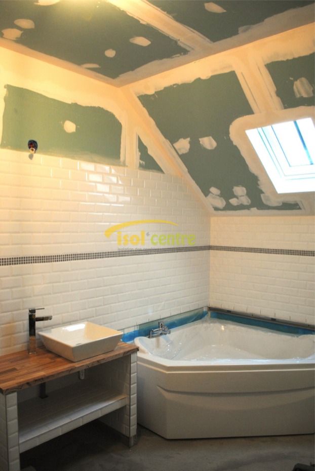 Salle de bains aménagée sous les combles, baignoire d’angle et fenêtre de toit