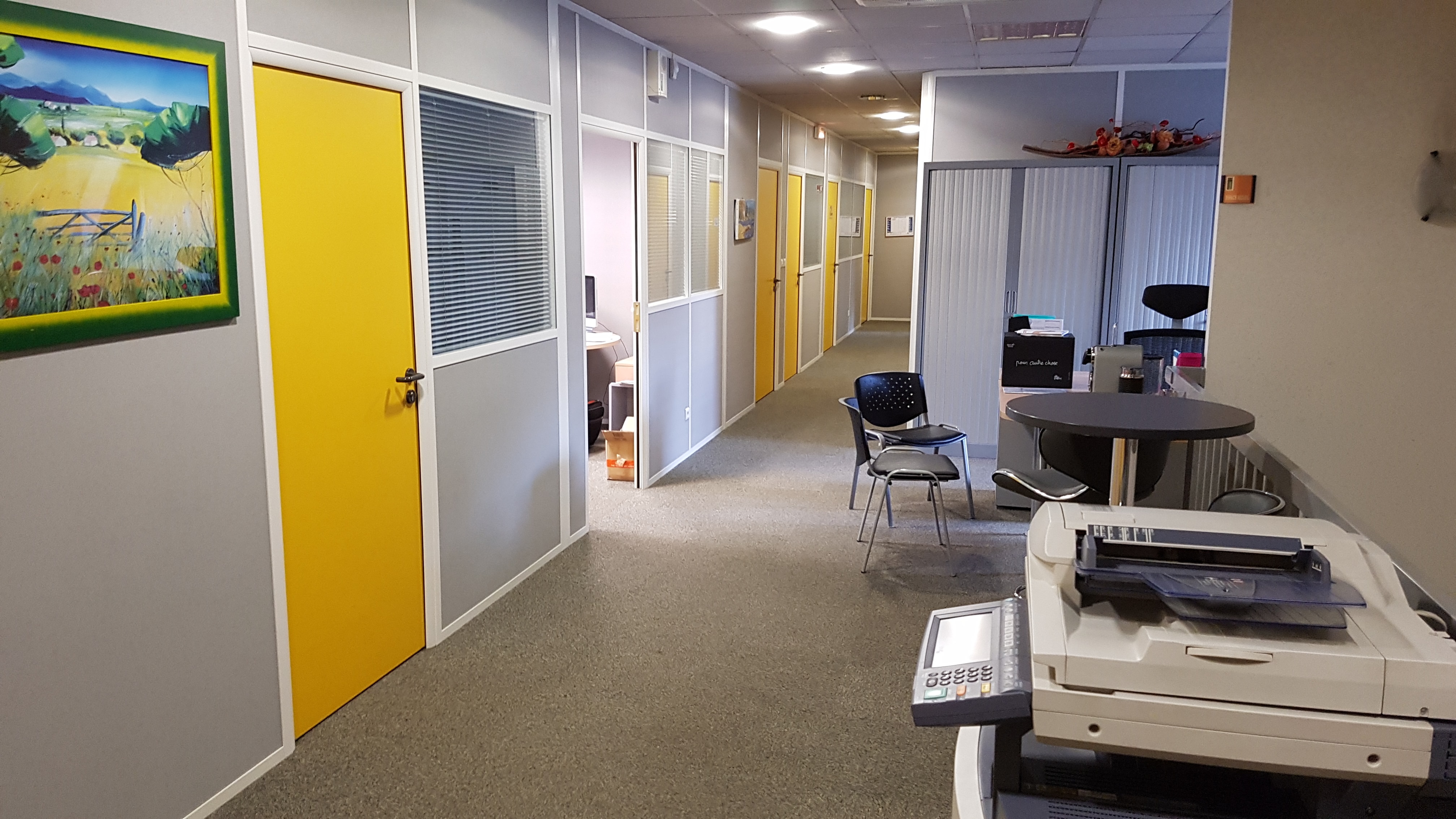Couloir des bureaux d’Isol’Centre à Orléans, portes jaunes et coin d’accueil